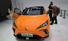 Visitors look at a MG4 electric car at the Beijing auto show