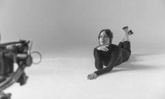 black and white photo of Kacey Musgraves lying on her front in a photographer's studio, looking to camera