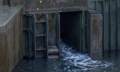 A sewage overflow outlet discharges into a river