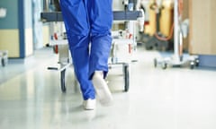 Legs of medic running with gurney along hospital corridor<br>GettyImages-475147771