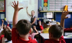 File photo of children at school raising their hands to answer a question.