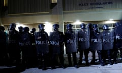 Police in riot gear line up