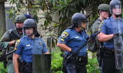 Police officers watch protesters gathering against another group of protesters in Baton Rouge, La., Sunday, July 10, 2016. Police officers responded to reports that protesters were en route to block Interstate 10 and prevent another group of protesters from marching. (Scott Clause/The Daily Advertiser via AP)