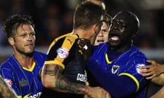 AFC’s Adebayo Akinfenwa, aka “The Beast” takes on Liam Hughes of Cambridge United as tempers flare at half time during the Sky Bet League Two match between AFC Wimbledon and Cambridge United at the Cherry Red Records Stadium