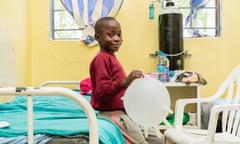 Desmond Muyenga plays with an inflated surgical glove in the haematology ward where he is being treated for sickle cell, in Lusaka, Zambia.