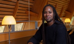 Jason Arday portrait in a warmly lit university library