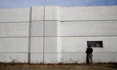 A man looks through the window of a seawall in Kesennuma, Japan.