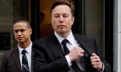 Elon Musk leaves a building with a dark suit and tie with white shirt, while putting an object into his inside jacket pocket