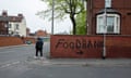 A graffiti sign reading 'food bank' on a wall as a man walks by