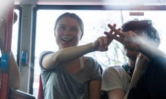 Climate activist Greta Thunberg flashes a V-sign along with another protester after being detained and driven off in a bus.