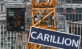 A worker lowering a Carillion sign at a construction site in 2018.