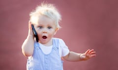 Stock image of a child holding a phone and looking shocked