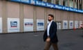 man walks past Fox news building in new york