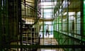 A prison officer walks across an empty landing of a prison