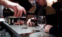 A bartender pours a glass of wine