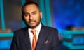 Amol Rajan wearing a suit and orange tie on the set of University Challenge