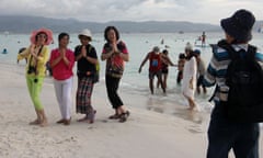 Tourists pose for photos on a beach on Boracay Island in January.