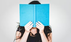 A woman hides her face behind a book