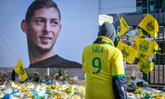 A Nantes fan wearing a replica shirt with Emiliano Sala's name on the back in front of a memorial to him at the club's Beaujoire stadium