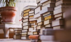 Piles of books stacked on a carpet.