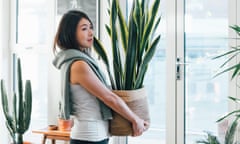 A woman holding a potted sansevieria