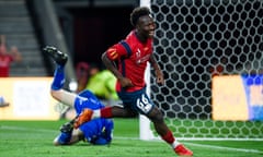 Nestory Irankunda of Adelaide United celebrates after scoring a goal as the opposition goalkeeper tumbles behind him