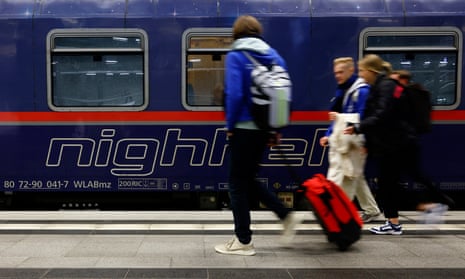 People walk past the Berlin-Paris night train on the station platform