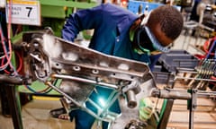 A factory worker welds a bike frame