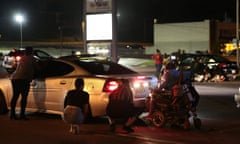 People hide behind cars after shots rang out in Ferguson, Missouri, during a demonstration on the second anniversary of Michael Brown’s death.