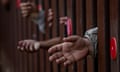 Closeup of brown arms between rusty bars