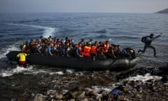 An Afghan migrant jumps off an overcrowded raft on to a beach on the Greek island of Lesbos October 19, 2015