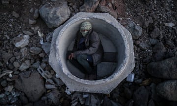 An Afghan boy hides inside a concrete sewer pipe after crossing the Iran-Turkey border.