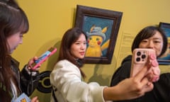 Visitors pose with a painting of Pikachu at the Van Gogh Museum