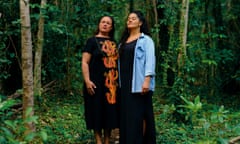 two women standing in a forested area