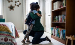 Mother embracing young daughter before school