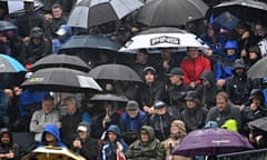 Spectators shelter from the rain beneath umbrellas at the British Open Golf Championship at Royal Liverpool Golf Course in Hoylake on Sunday.