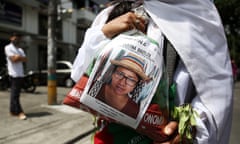 An indigenous woman shows a portrait of Cristina Bautista Taquinas, an indigenous leader killed by illegal armed groups, during a march in Cali, Colombia, last June.