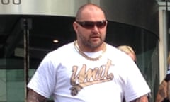 man in sunglasses wearing a gold chain and white t-shirt saying "unit"