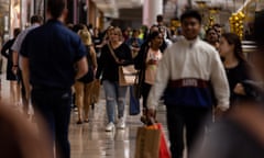 Interior of shopping centre crowded with people carrying purchases