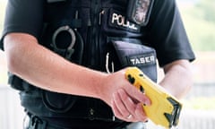 A British police officer holding a axon taser X2 conducted electrical weapon or stun gun.