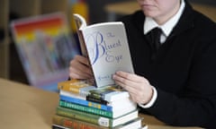FILE - Amanda Darrow, director of youth, family and education programs at the Utah Pride Center, poses with books, including "The Bluest Eye," by Toni Morrison, that have been the subject of complaints from parents in Salt Lake City on Dec. 16, 2021. The wave of book bannings around the country has reached a level not seen for decades. (AP Photo/Rick Bowmer, File)