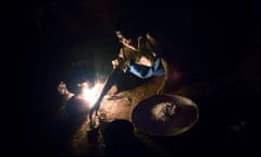 Mwaiwawo Mphandula, 13, cooks maize porridge in the kitchen of the family house as the sun goes down, in a village 30 miles from Lilongwe