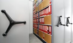 Sliding shelves with folders of documents.