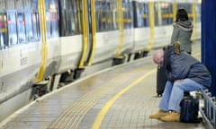 Passengers wait on a train platform