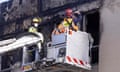 Firefighters inspect the Loafers Lodge hostel where a fire broke out, killing at least six people 