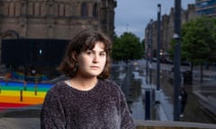 Isabelle Murray, with shoulder-length hair, leans against a concrete wall, hands folded, in front of the University of Edinburgh’s McEwan Hall