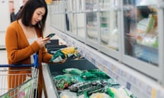 Woman scans barcode on packaging with smartphone in grocery store