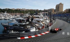 A Ferrari car rounds a bend at Monaco harbour