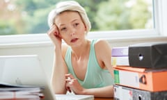 A lady on a laptop, looks at piles of files