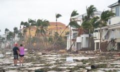 People walk along the beach looking at property damaged by Hurricane Ian on 29 September, 2022 in Bonita Springs, Florida.